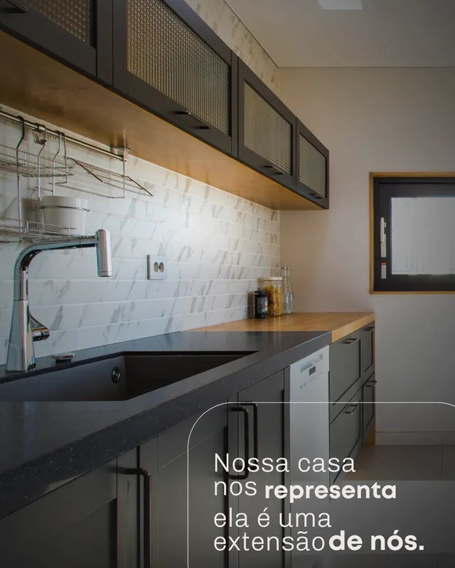 Publicação do perfil @brisa.eng: cozinha com marcenaria escura e bancada iluminada