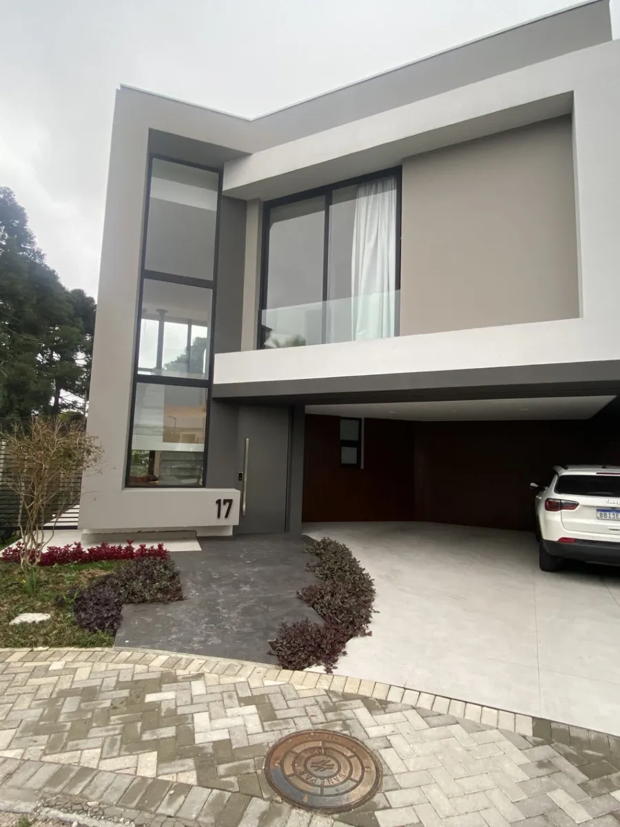 Fachada da Obra HV17, residência concluída, com jardim e pátio de acesso
